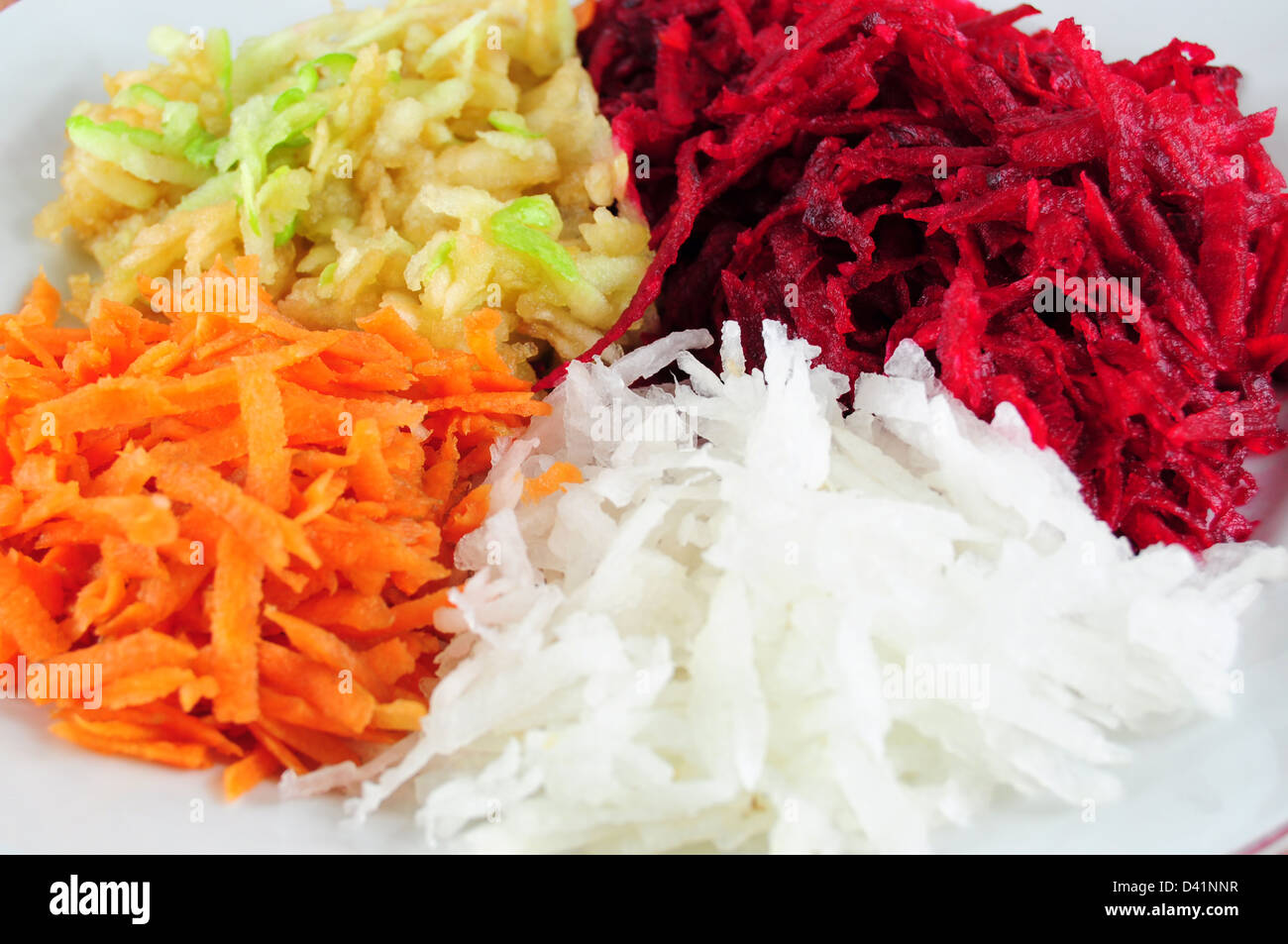 Salad from shredded beetroot, turnip, carrots and apple - closeup view Stock Photo