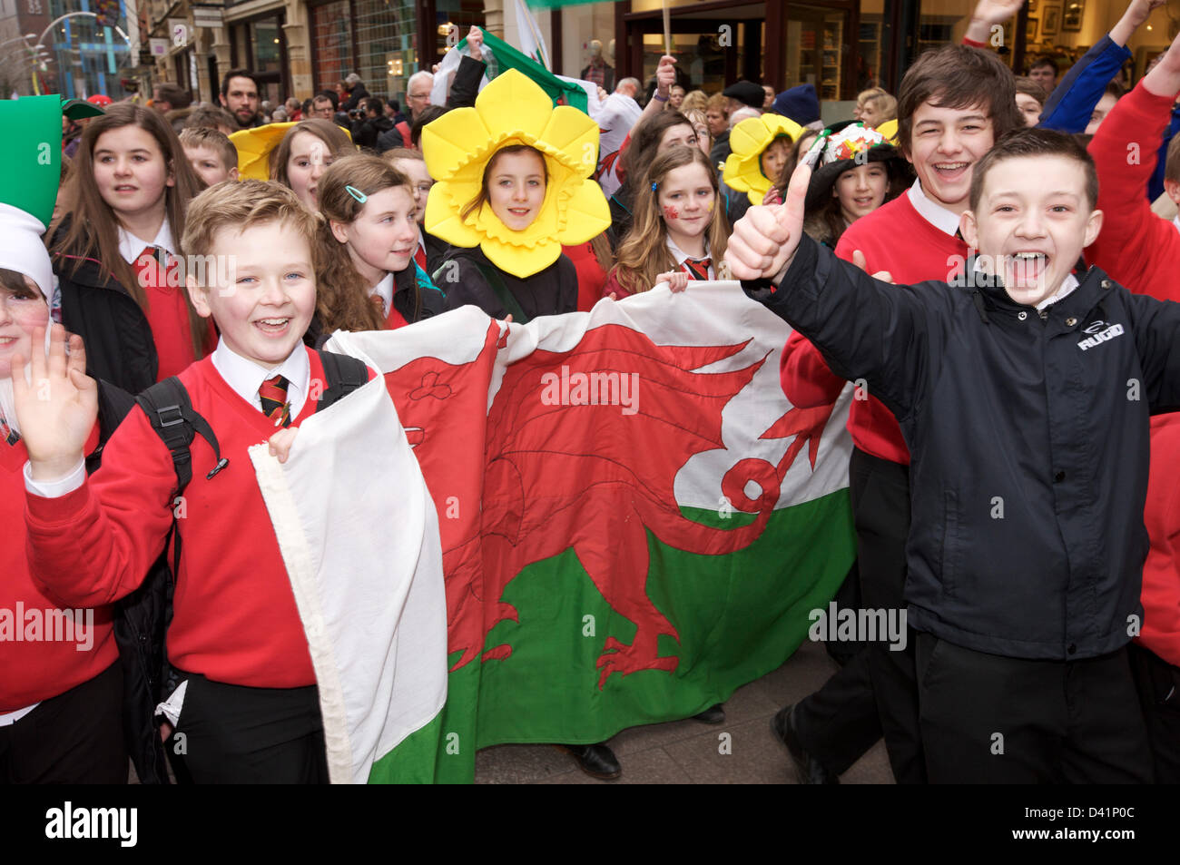 Daffodil,hat,wearing,and Welsh Dragon,flag,Cardiff, Wales, UK. 1st March. St David's Parade held on St David's Day in centre of Cardiff. Stock Photo