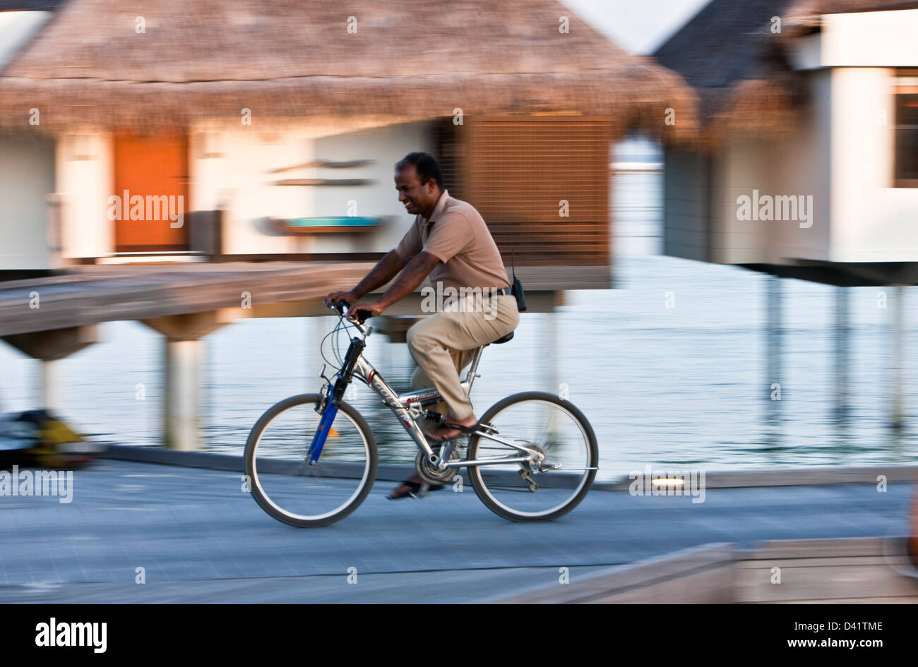 Groundsman on mountain bike in resort of Kuda Hura, Maldives Stock Photo