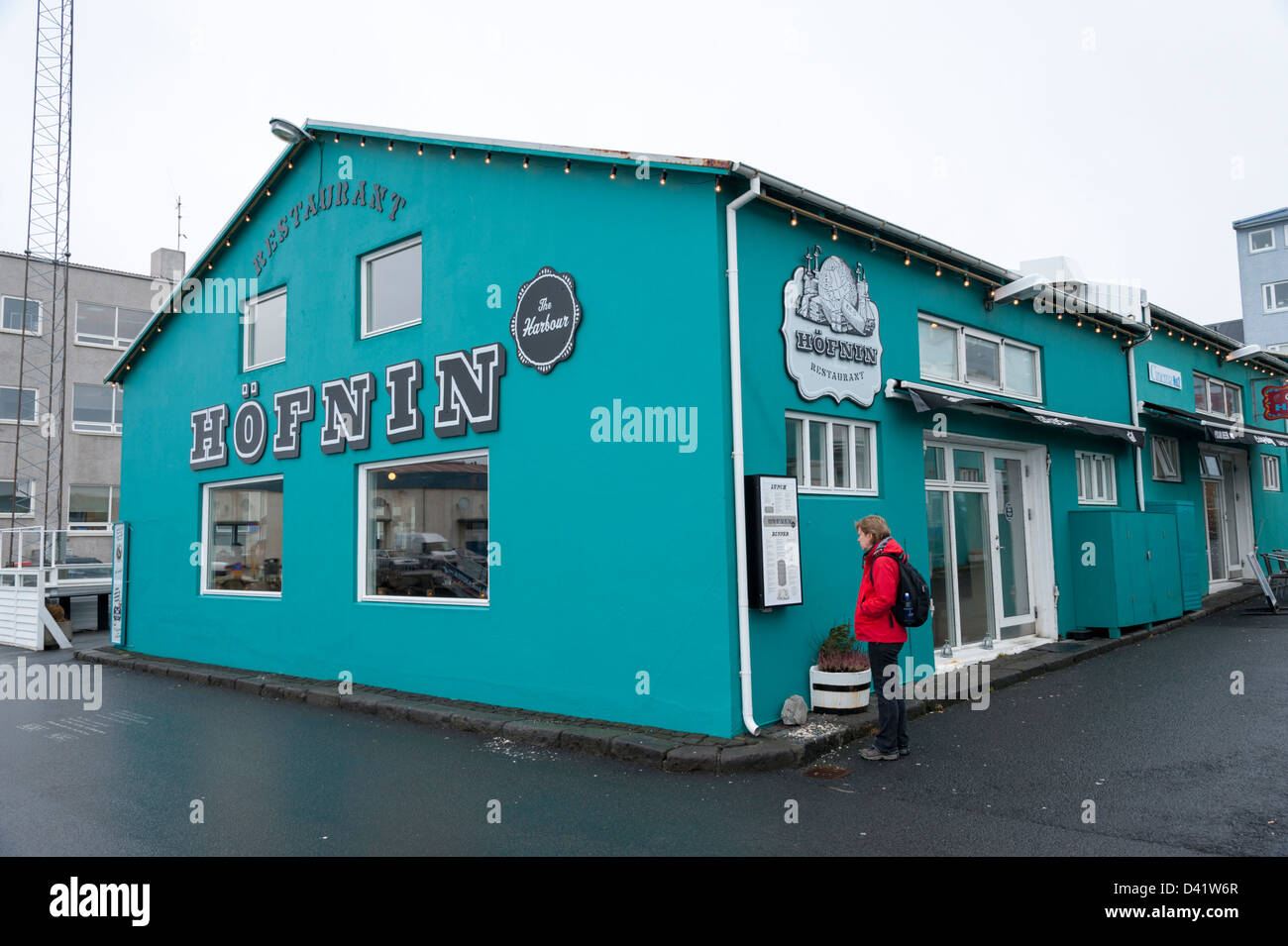 A woman reading the menu outside The Hofnin fish restaurant on the