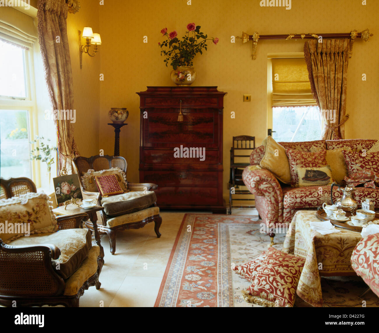 Comfortable Bergere chairs and sofas in yellow cottage living room with antique cheston chest