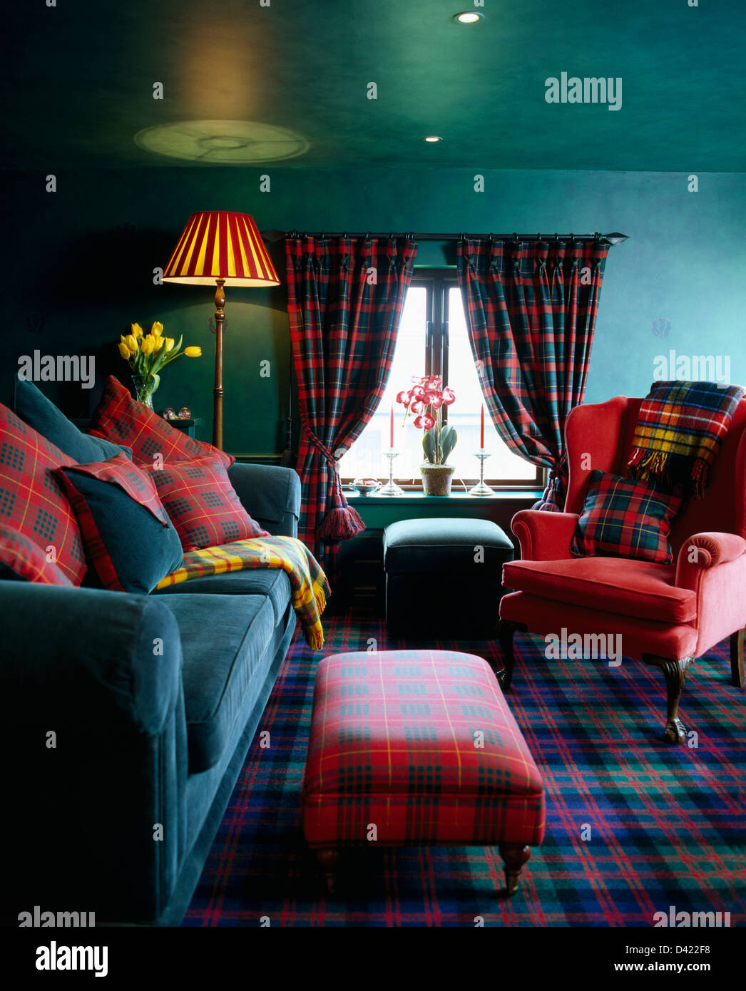 Red tartan upholstered stool and matching cushions on turquoise velvet sofa  and red armchair in turquoise green living room Stock Photo - Alamy