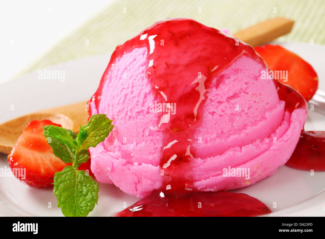 Scoop of pink ice cream with strawberry sauce Stock Photo
