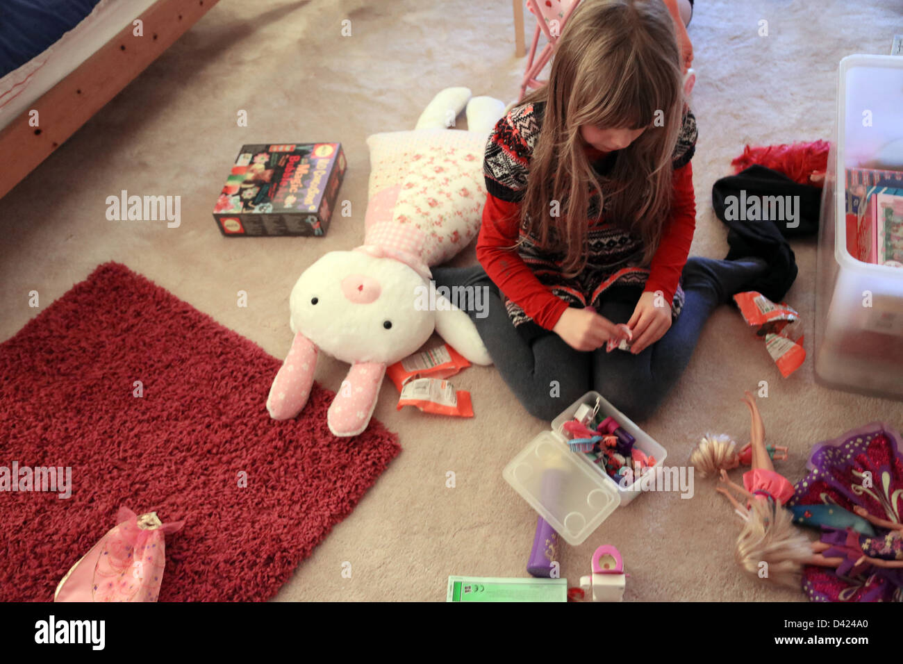 6 Year Old Girl Playing With Her Dolls In Her Bedroom England Stock Photo