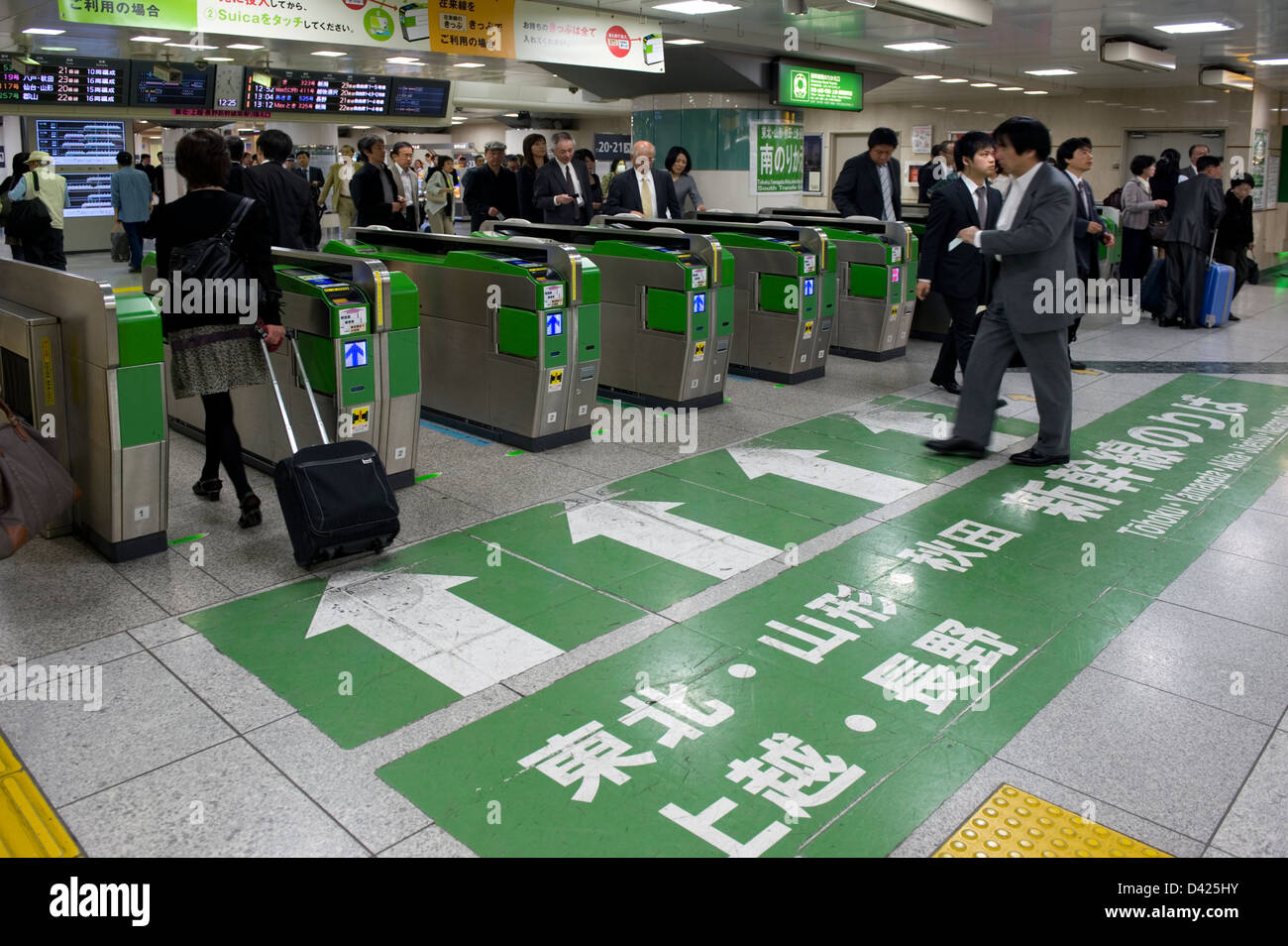 Businessmen and commuters passing through electronic wickets on their way to shinkansen bullet train platforms at Tokyo Station Stock Photo