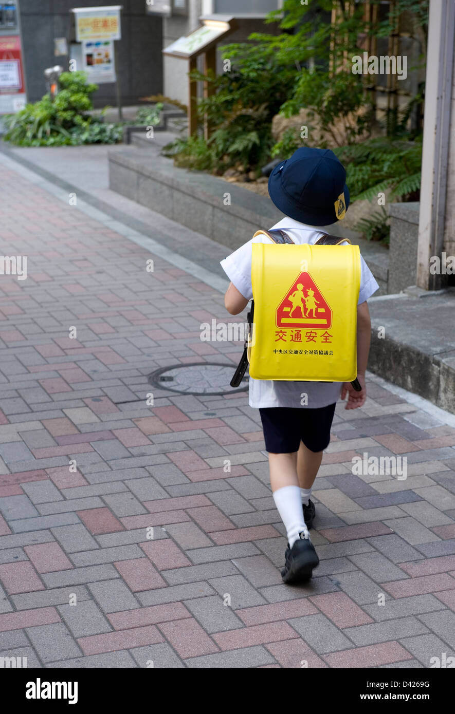 Elementary school boy with cap walking home from school in Tokyo