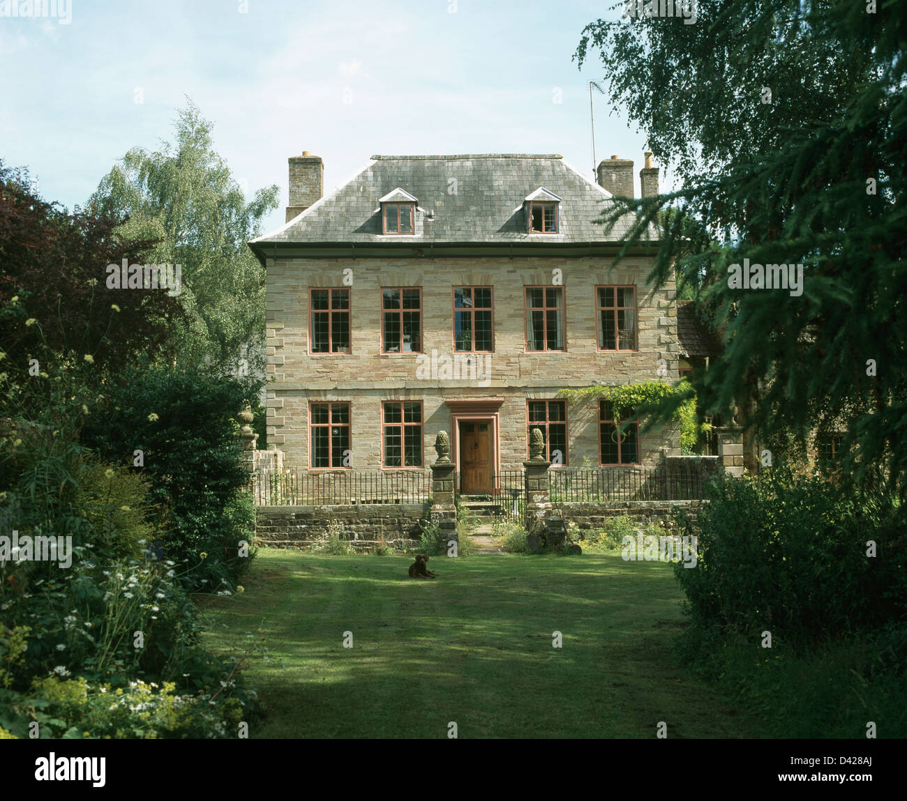 Large country house in Gloucestershire with shrub borders around lawn