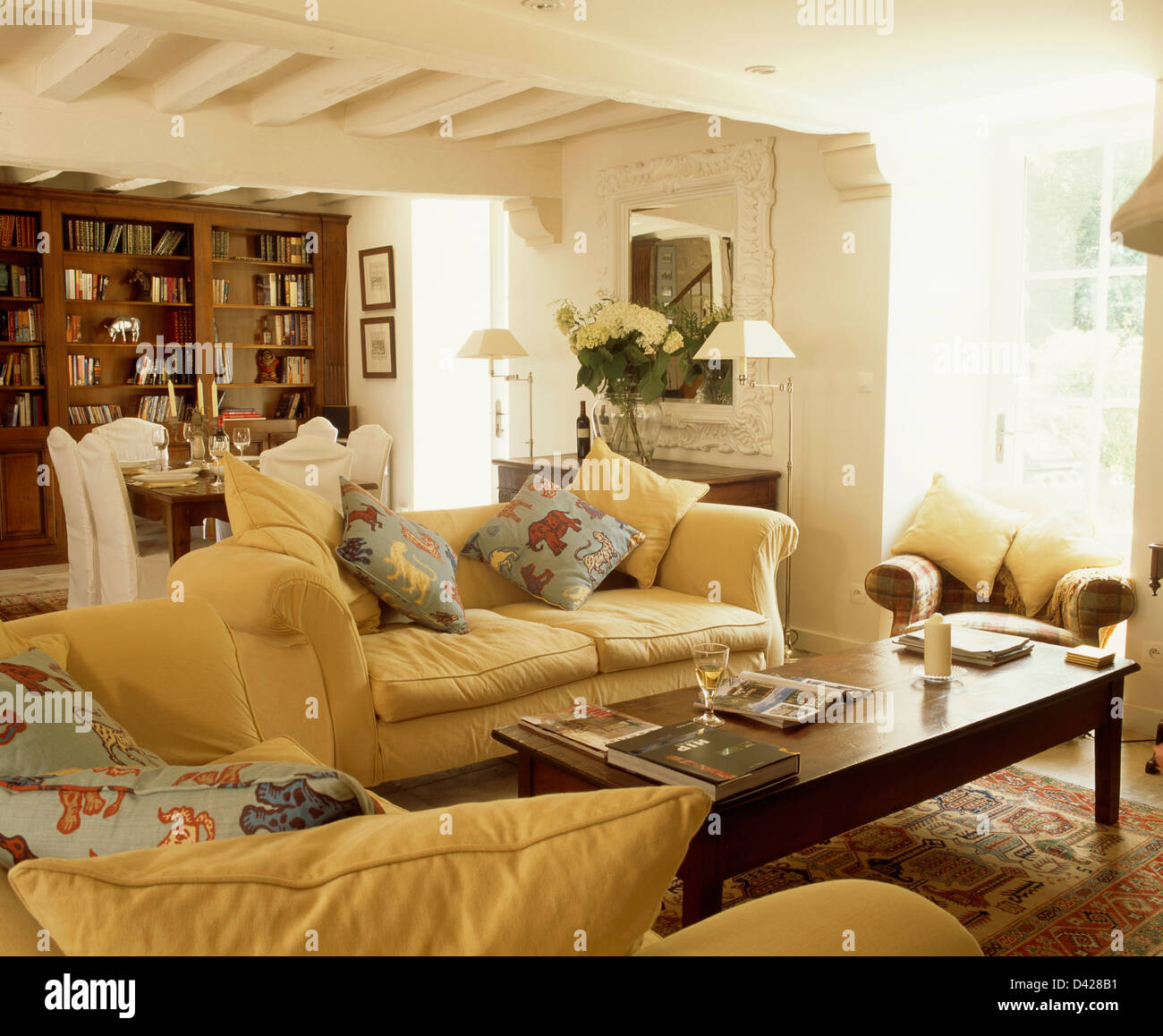 Yellow Sofas With Animal Patterned Cushions Around Antique Coffee