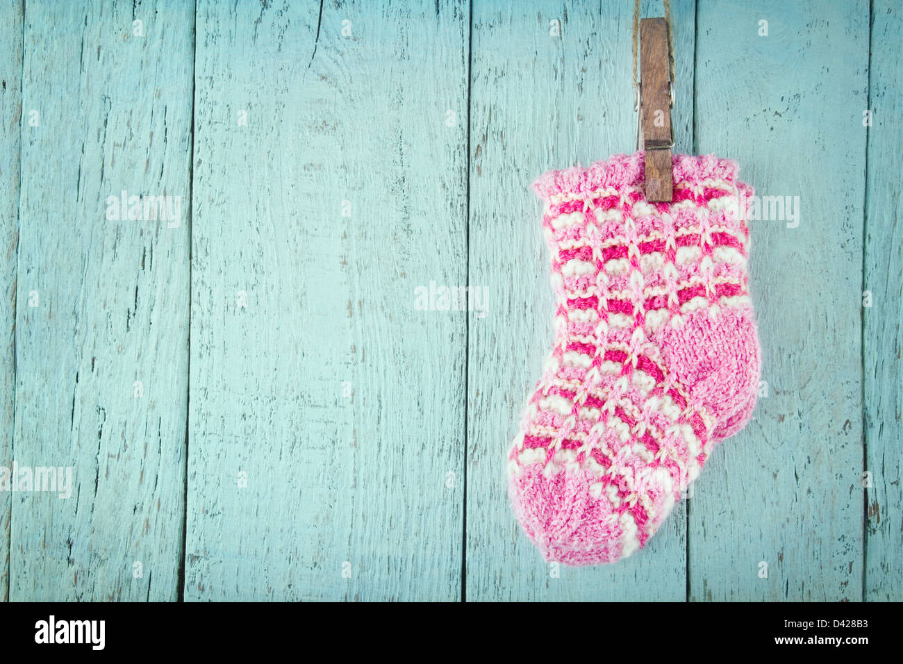 Pink baby socks on a blue wooden rustic background with copy space Stock Photo