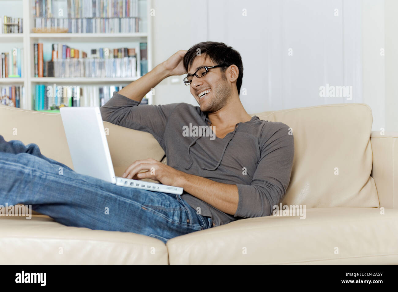 A man very comfortable surfing the internet using a laptop. Stock Photo