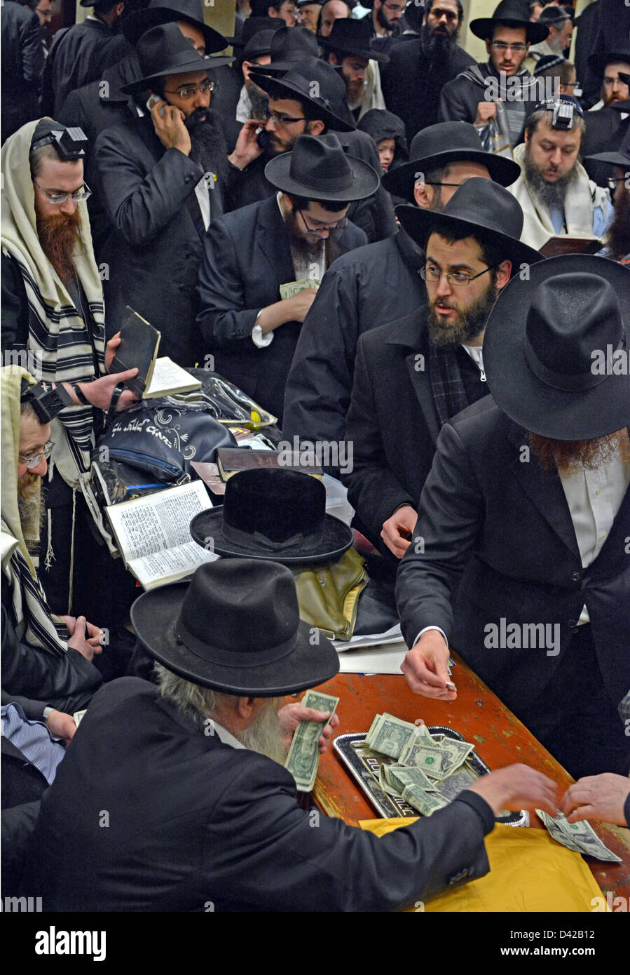 Machatzit HaShekel, the ritual of giving charity the day before the Jewish holiday of Purim. In Brooklyn, New york. Stock Photo