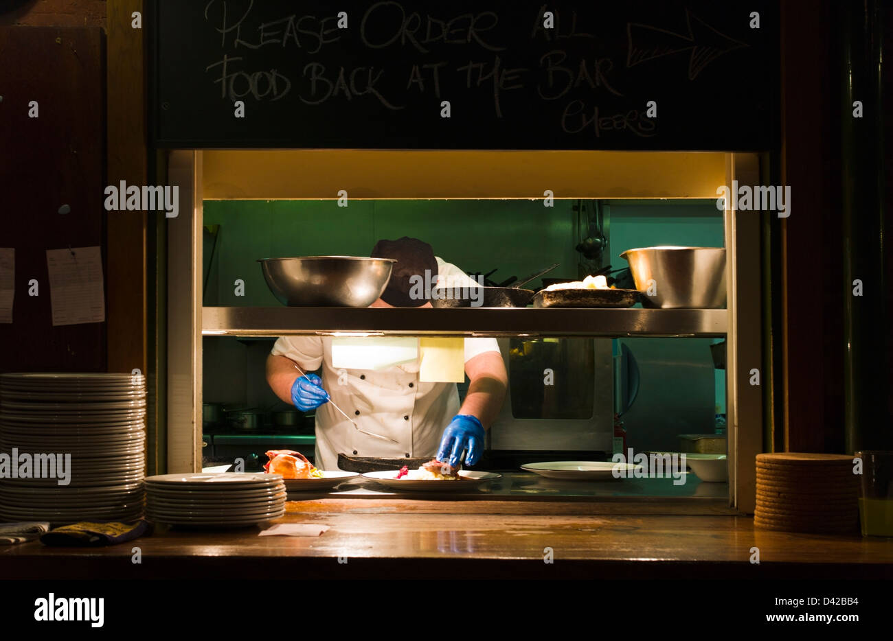 Restaurant cook at a serving hatch Shrewsbury Shropshire UK Stock Photo