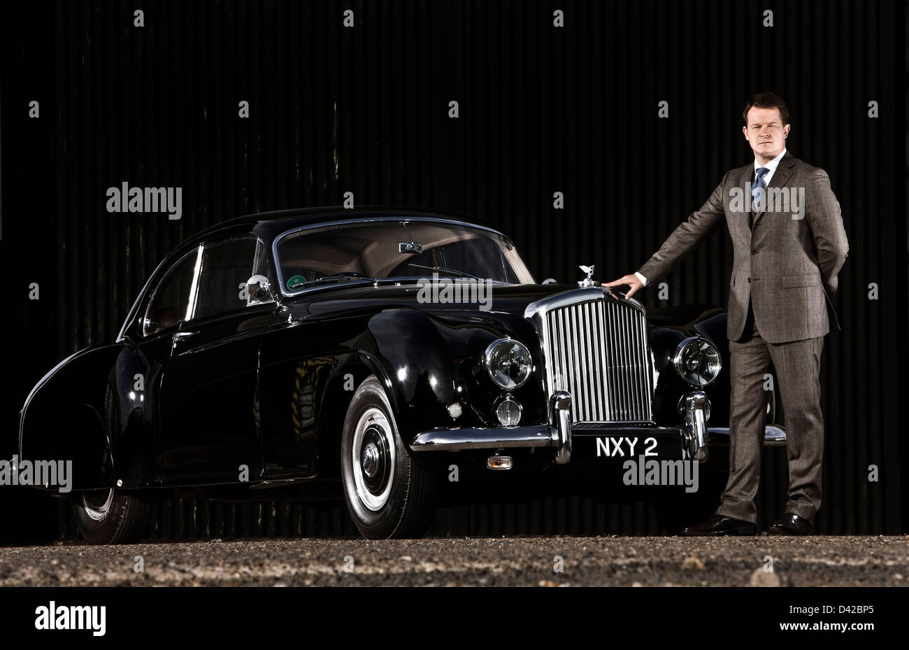 Chauffeur stands with Bentley R Type Continental car Stock Photo