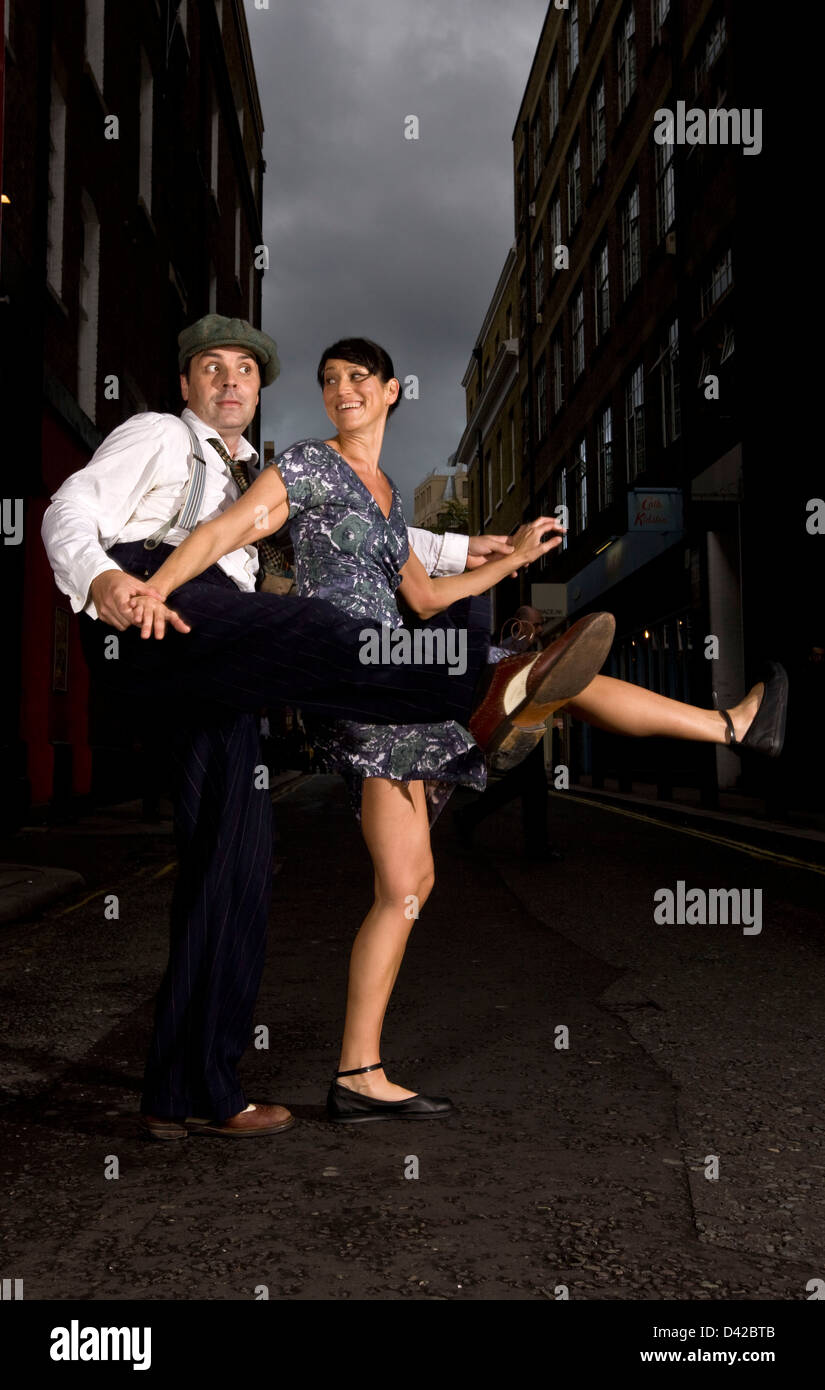 Couple dancing the lindy hop in urban street, kick step Stock Photo