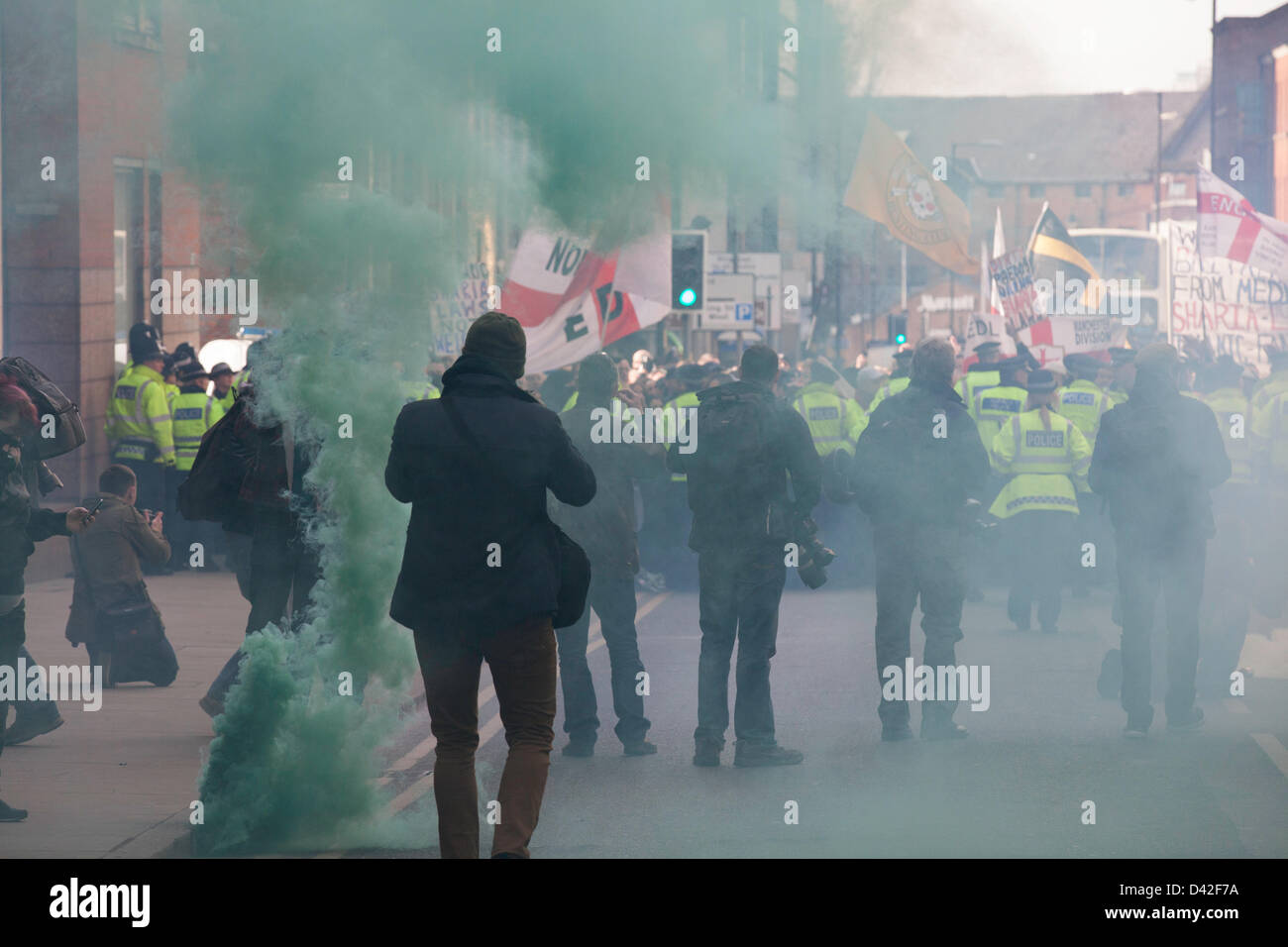 Manchester, UK. 2nd March 2013. Members of the far-right English Defence League (EDL) clash with police during a protest in Manchester. Approximately 300 members of the 'Islamophobic' group attended.The EDL march was under strict police supervision while heading to Albert Square. EDL members used green smoke bombs while chanting slogans. Credit: Lydia Pagoni/Alamy Live News Stock Photo