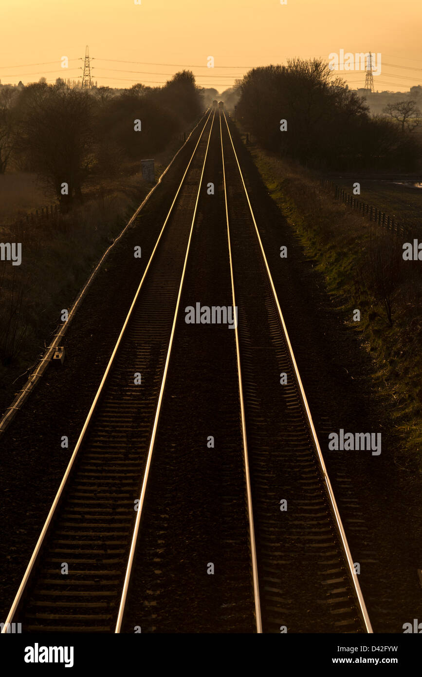 Trains converging railway lines in the evening sun. Stock Photo