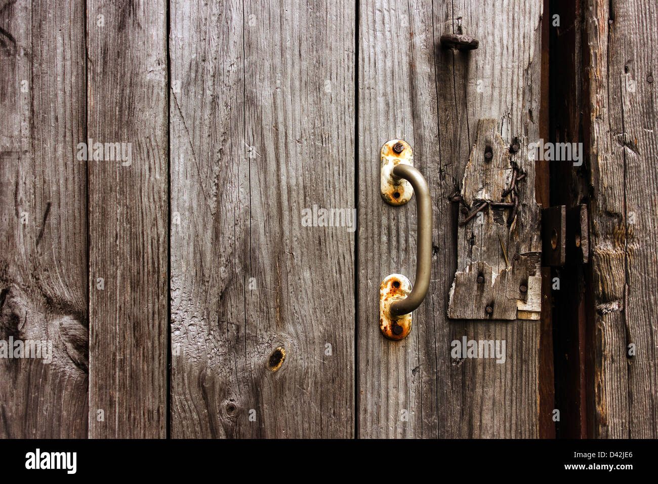 Old natural wooden texture with door handle. Broken door lock. Stock Photo