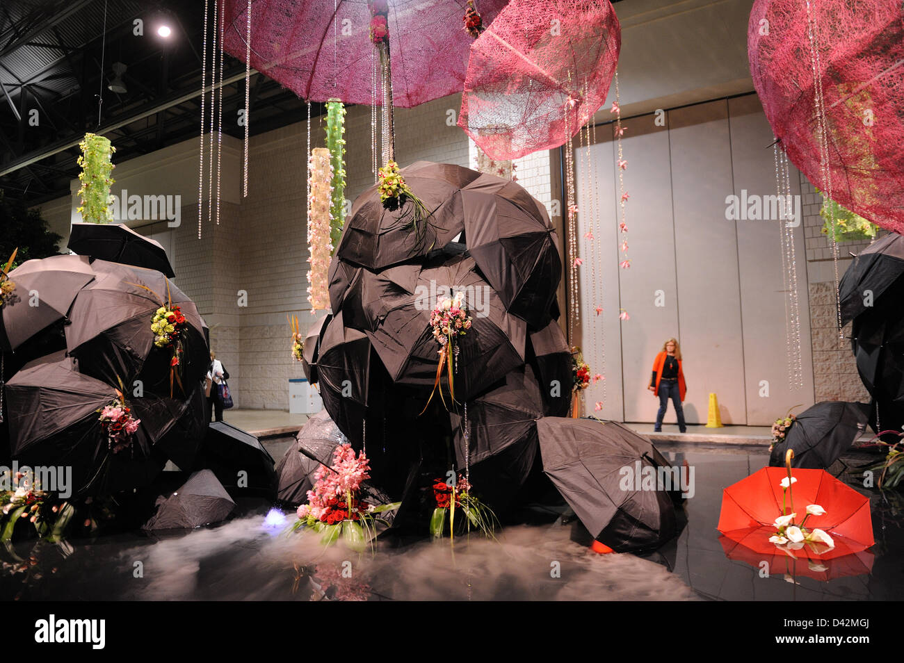Philadelphia, PA, USA. March 1, 2013. The Philadelphia Flower Show, the largest indoor flower show in the world, opened to the public on March 2, 2013 at the Pennsylvania Convention Center in Philadelphia, Pa. This year's theme, "Brilliant," celebrates Great Britain's landscapes and cultural icons. Among the exhibits is one called "London Fog" with umbrellas and flower arrangements poised above a reflecting pool. The flower show, produced by the Pennsylvania Horticultural Society, was first held in 1829. This year's show runs through March 10. Photo: Terese Loeb Kreuzer/Alamy Live News Stock Photo