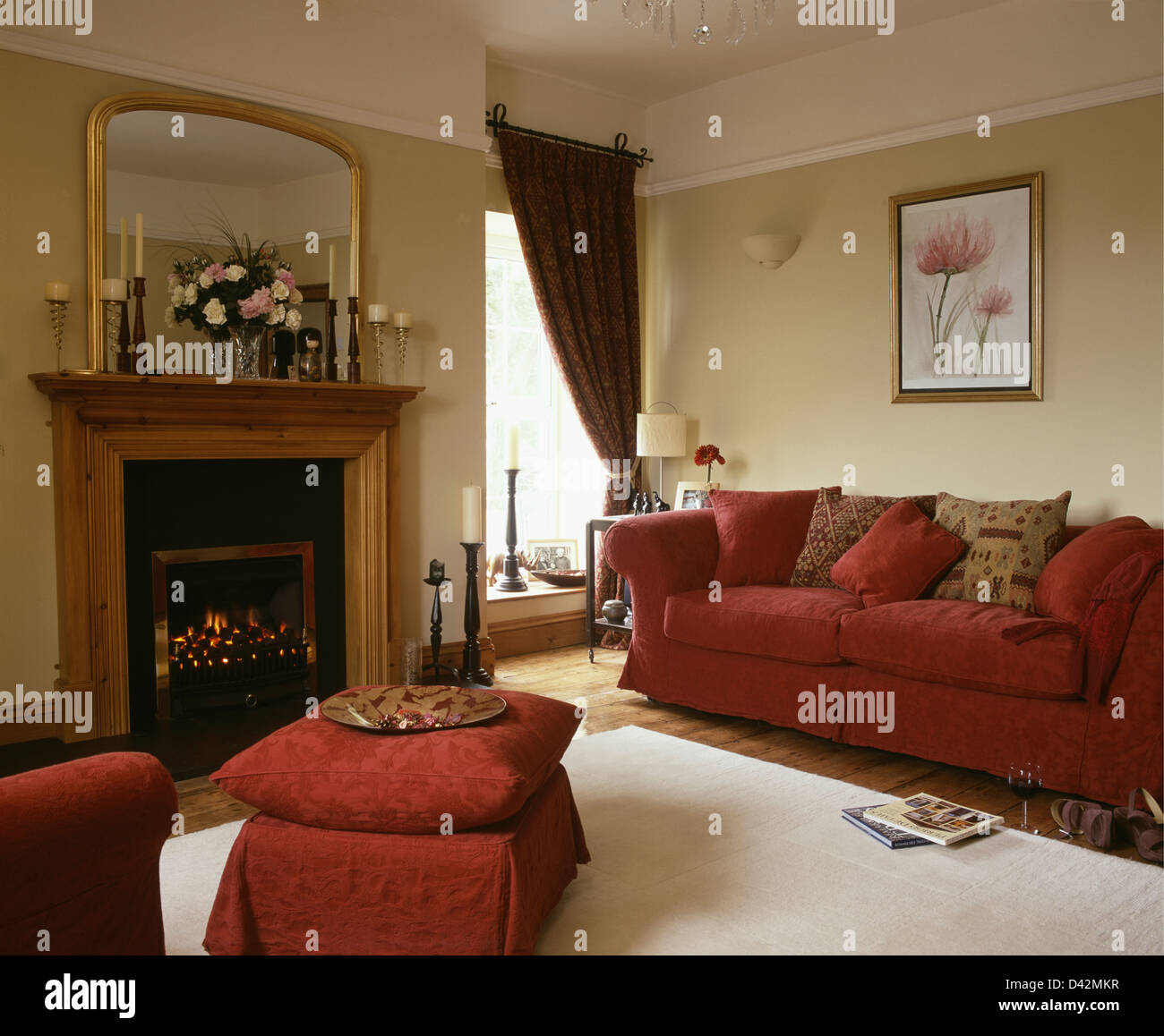 Red damask sofa and matching upholstered stool in townhouse living room