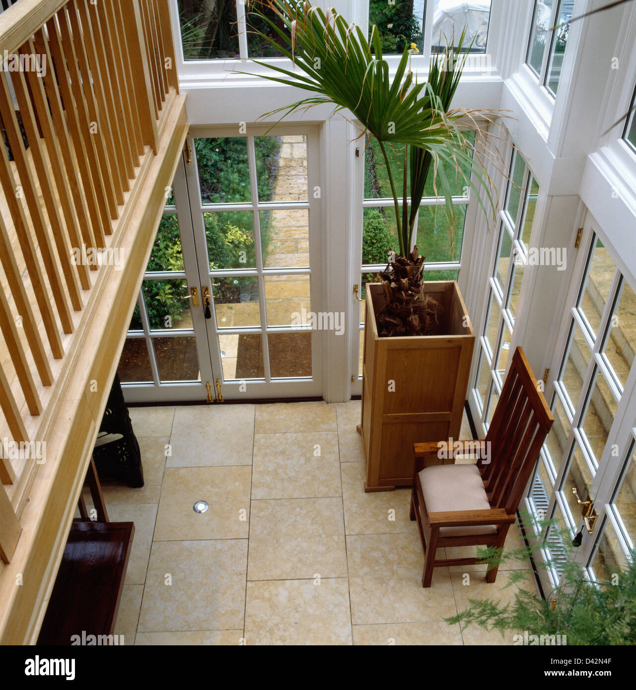 Birdseye view of conservatory hall with stone tiled floor and palm tree