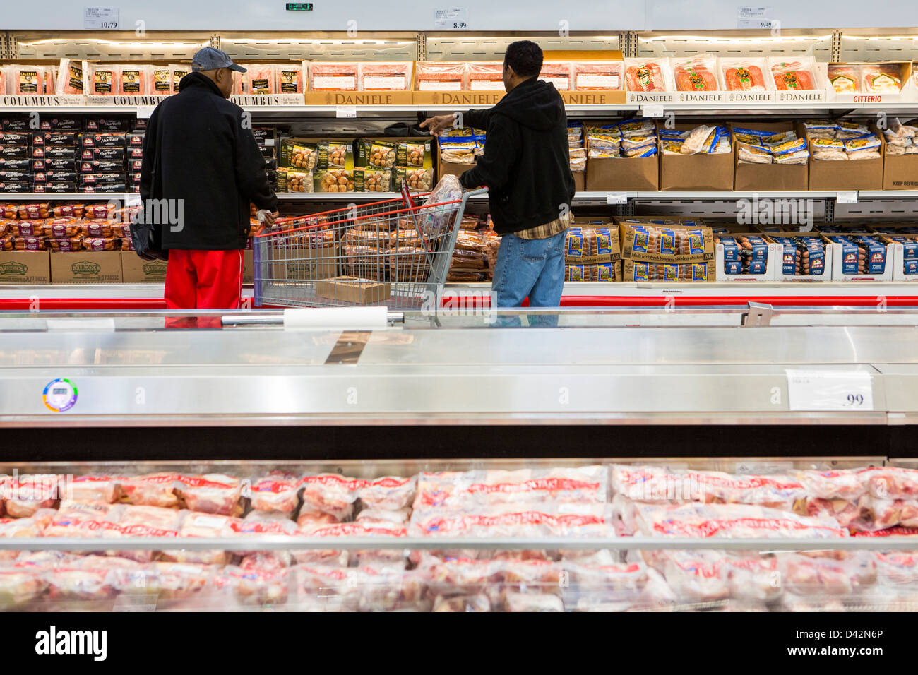 Customers shopping in the meats section of a Costco Wholesale Warehouse Club. Stock Photo