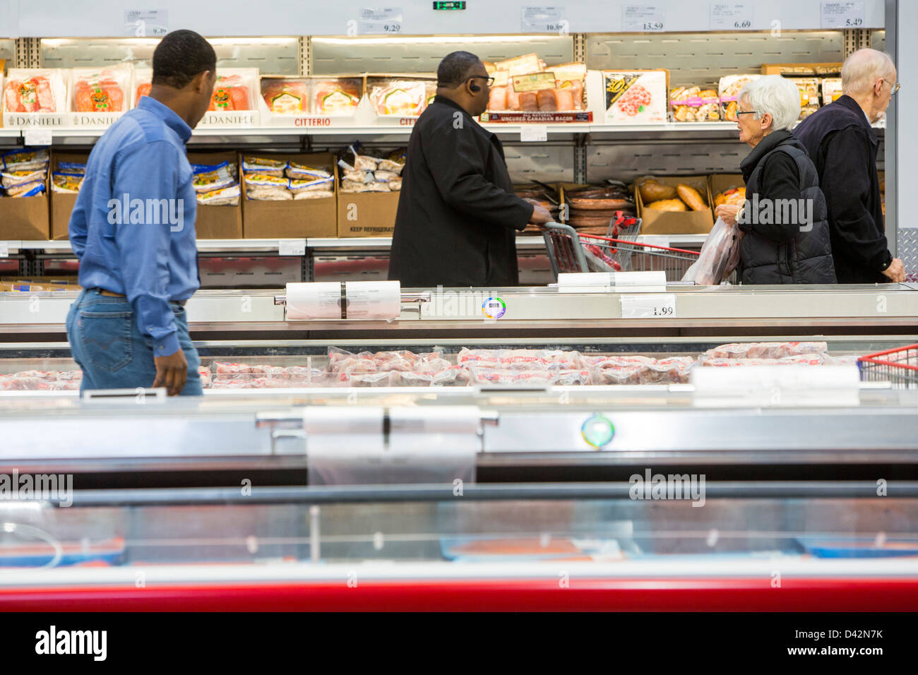 Customers shopping in the meats section of a Costco Wholesale Warehouse Club. Stock Photo