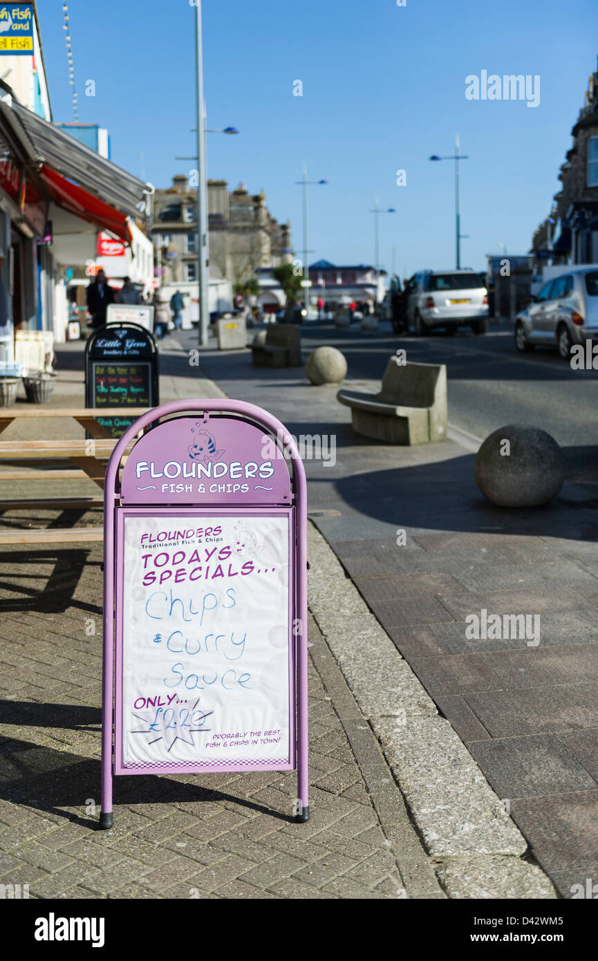 A sign advertising a fish and chip shop in a street in Newquay Stock