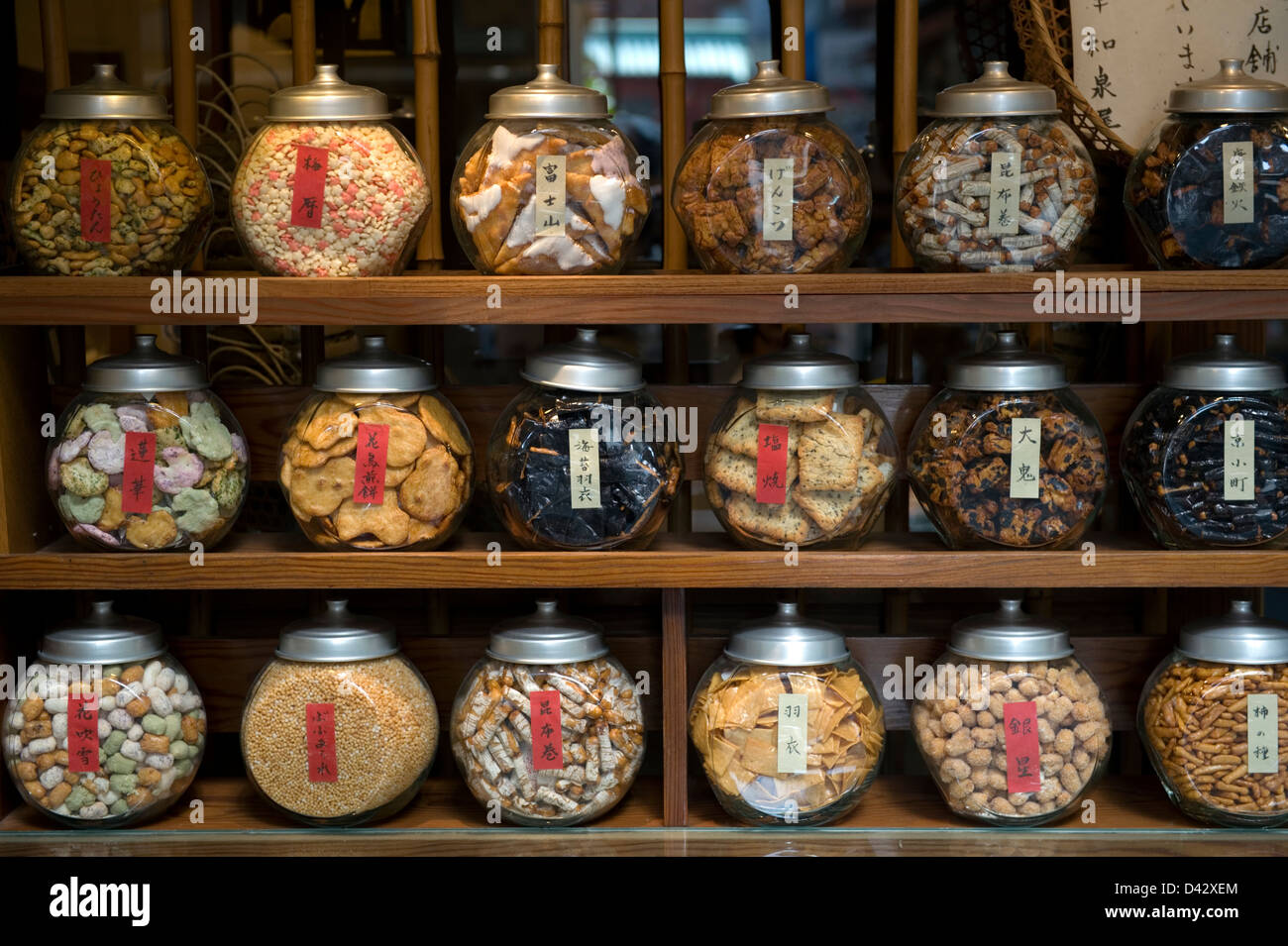 Senbei, or sembei, (large rice crackers), arare (bite-sized crackers) and other snacks on display in separate glass jars at a shop in Tokyo, Japan. Stock Photo