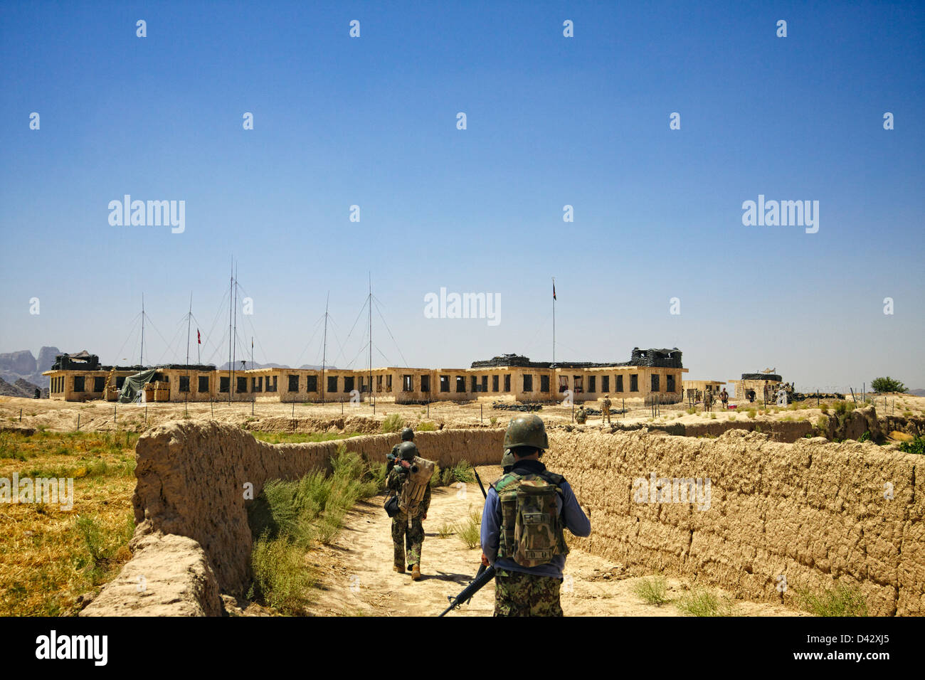 A joint patrol between International Security Assistance Force soldiers and Afghan National Army Soldiers returns to their base. Stock Photo