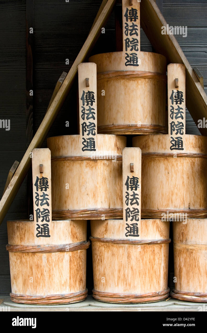 A stack of old traditional wooden water buckets for putting out fires at a temple in Tokyo. Stock Photo