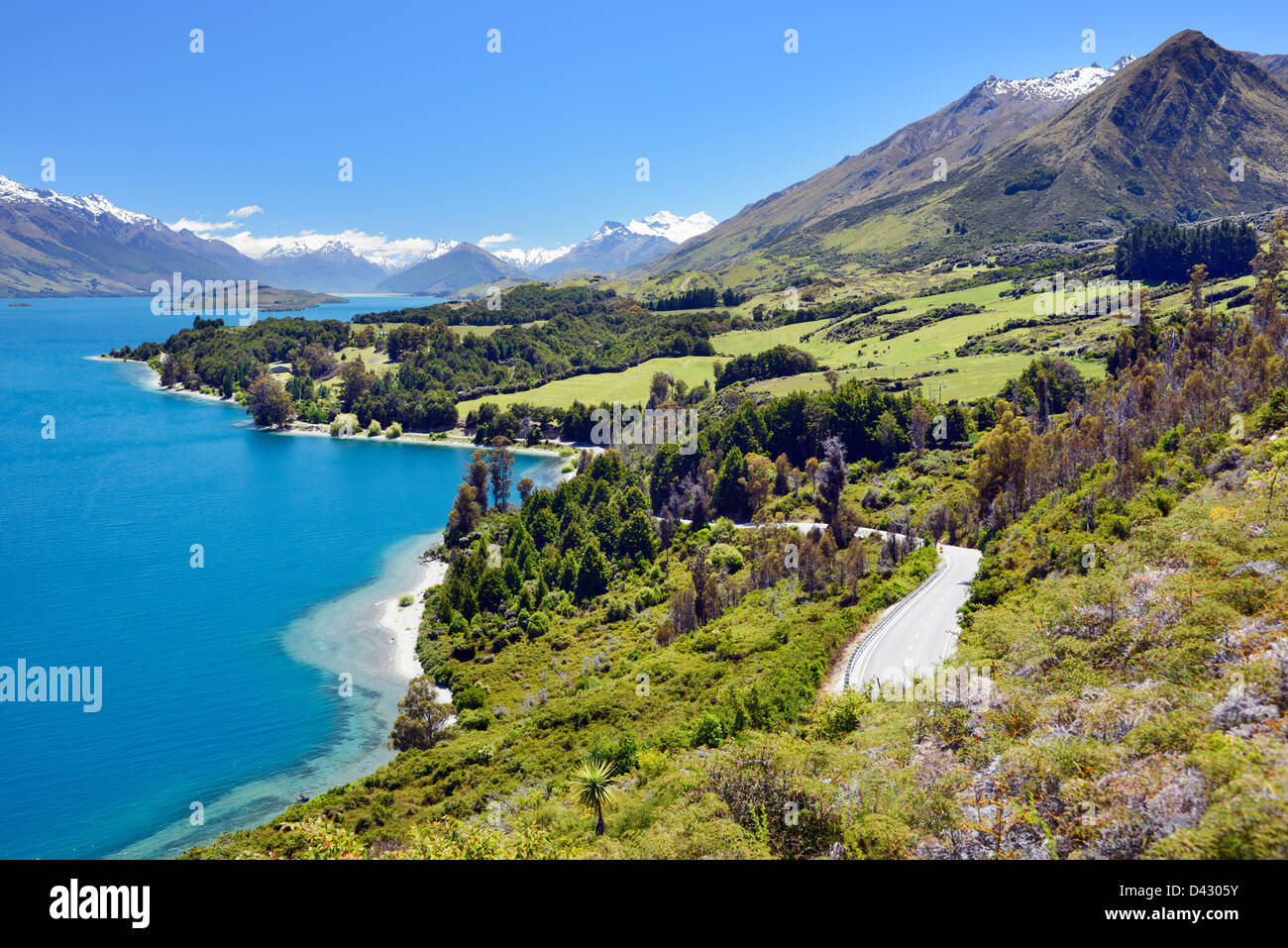 The Glenorchy Queenstown road running through farmlands and between Lake Wakatipu and the mountains Stock Photo