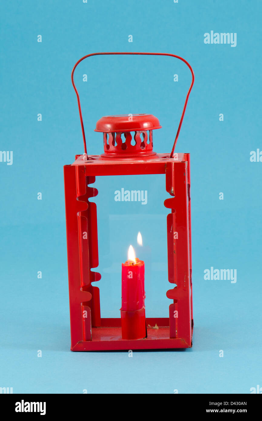 steel red retro candlestick lamp with handle and candle burn on blue