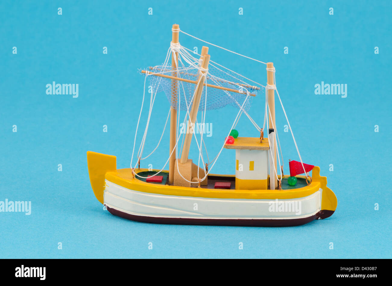 wooden handmade object boat ship with sail model decoration on blue background. Stock Photo