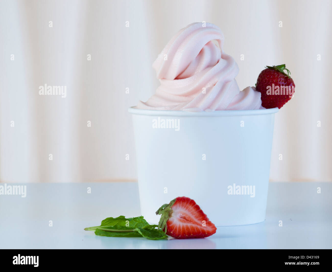 Cup of strawberry frozen yogurt or soft serve ice cream with fresh