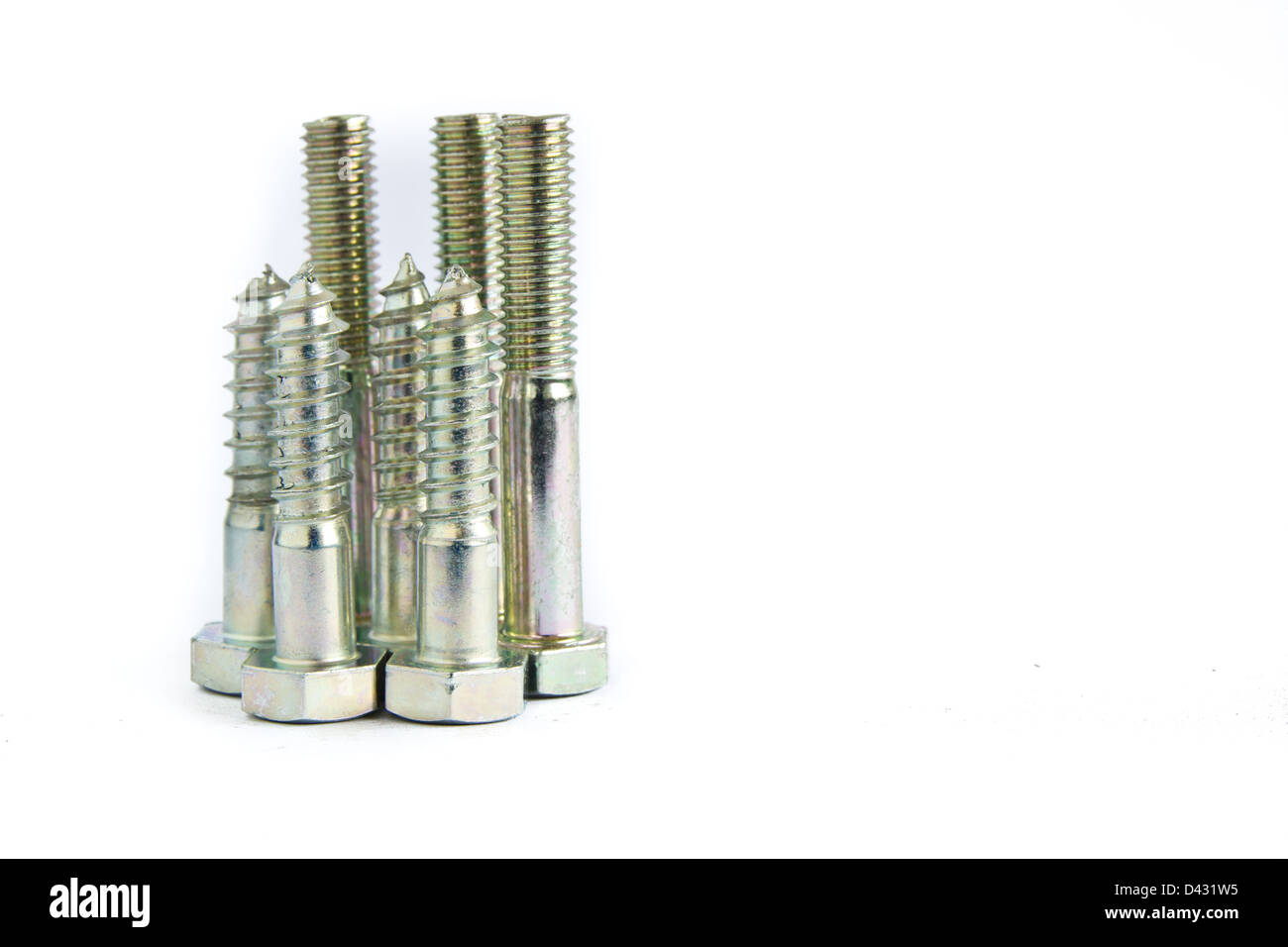 random pile of hexagonal threaded steel bolts or screws on white Stock Photo