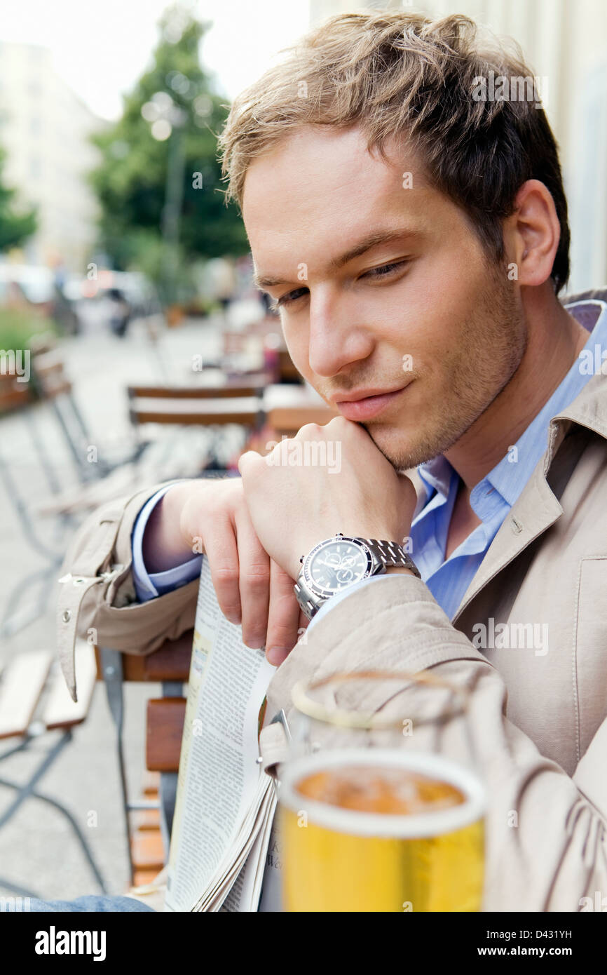 Handsome man in smart casual clothes sitting in an outdoor cafe Stock Photo
