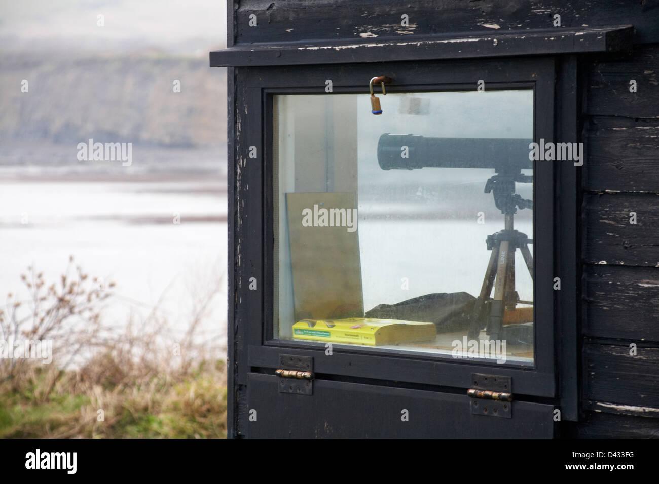 looking out to sea - telescope in range wardens hut at Kimmeridge Bay in February Stock Photo