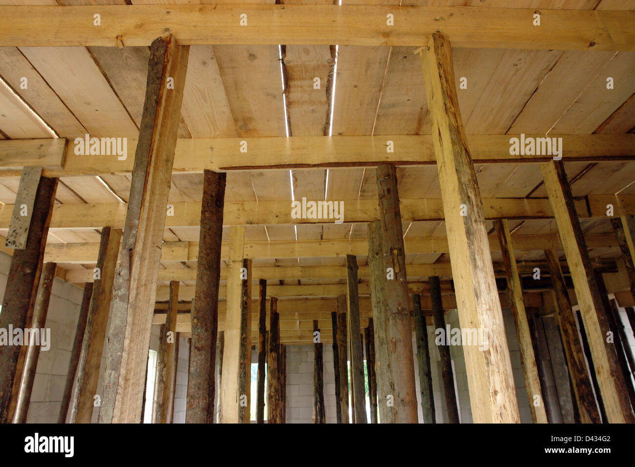 Wooden shuttering supported by props being ready for casting concrete slab Stock Photo