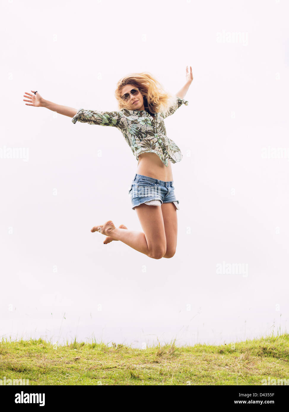 Happy woman jumping into the clouds Stock Photo