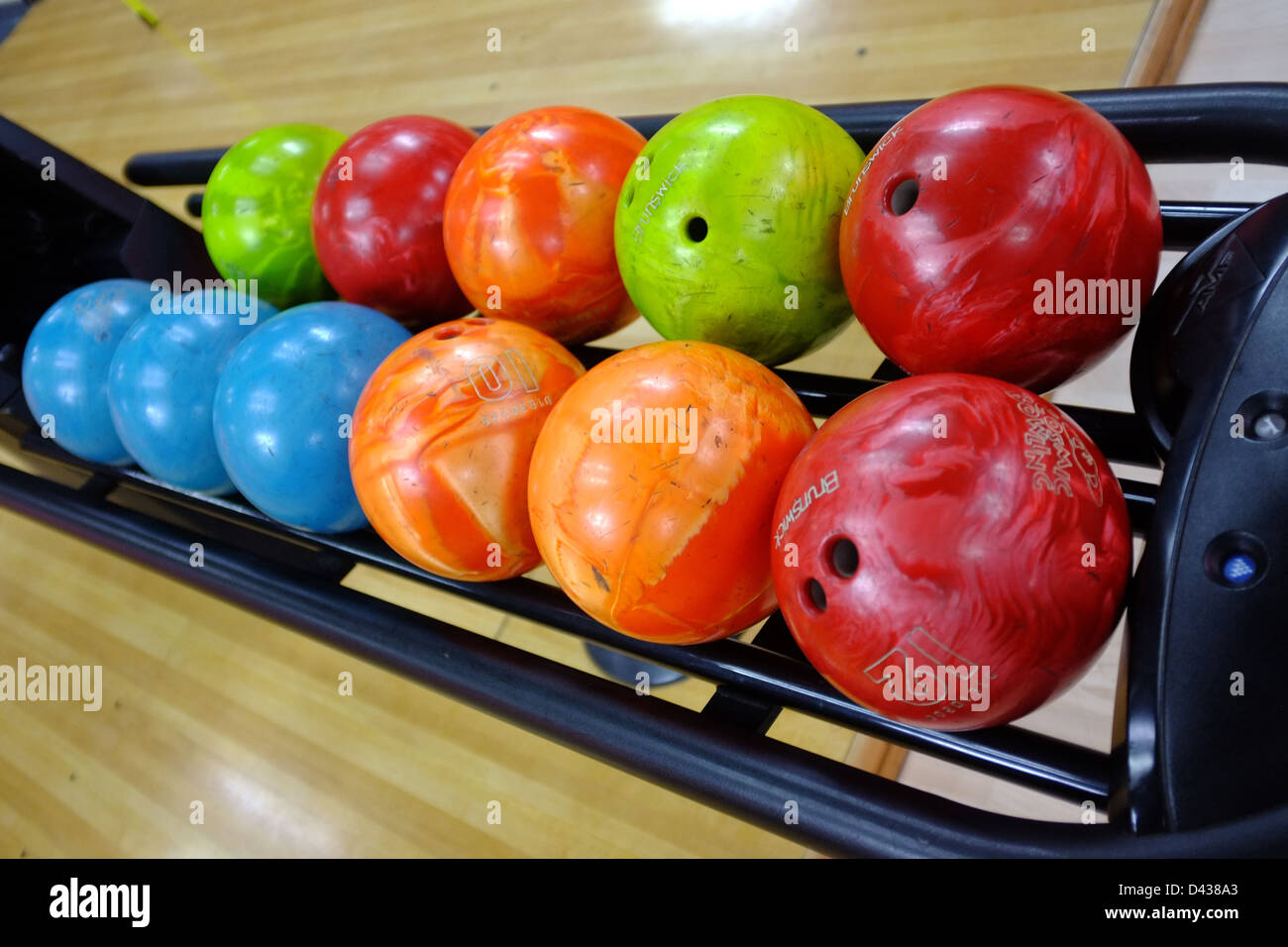 A tray of bowling balls of different weights and colours at a bowling