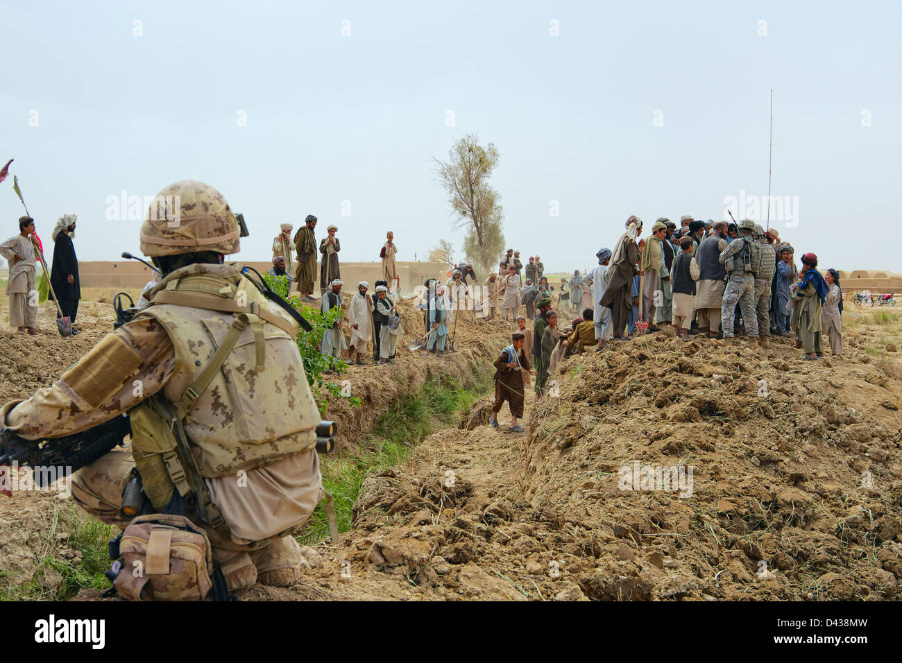 US and Canadian Forces oversee the construction of an irrigation canal south of Kandahar City, Afghanistan. Stock Photo