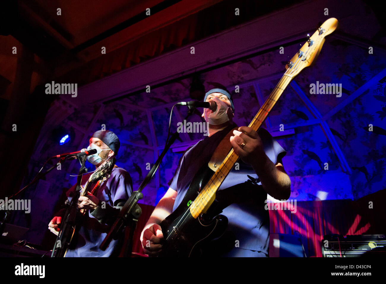 Alternative rock band Clinic in concert at the Deaf Institute, Manchester, on 2 March 2013. The band perform live with surgical masks and gowns. Guitarist Ade Blackburn left and bass player Brian Campbell on the right. Stock Photo