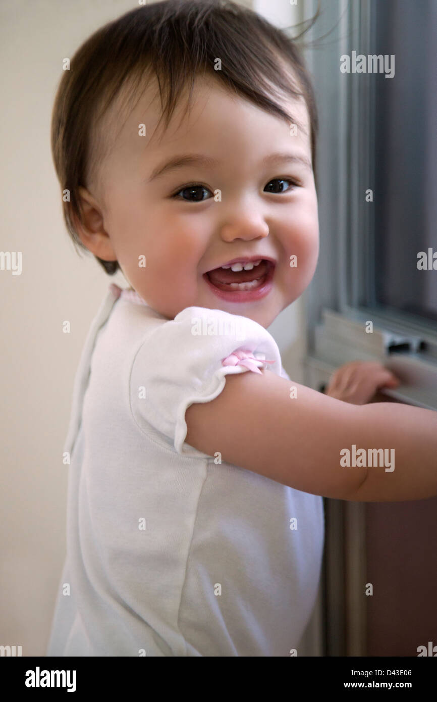 Smiling baby in front of a window Stock Photo