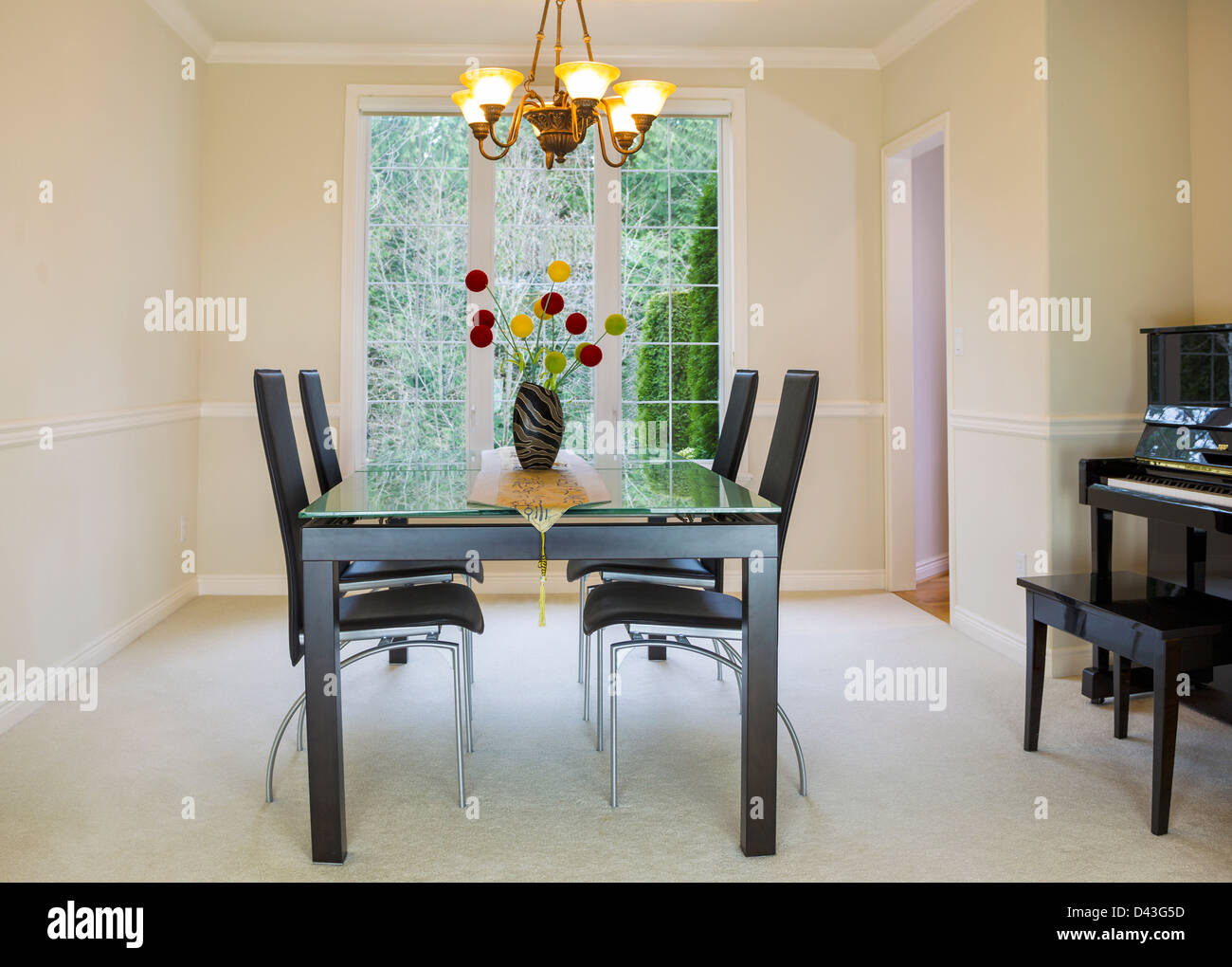 Horizontal photo of family formal dining room with daylight coming through large windows in background Stock Photo