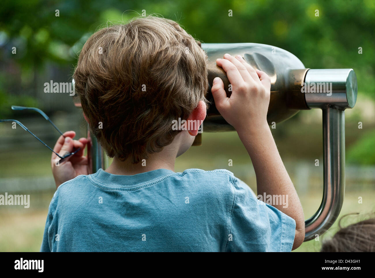 Boy looking through a viewing scope. Stock Photo