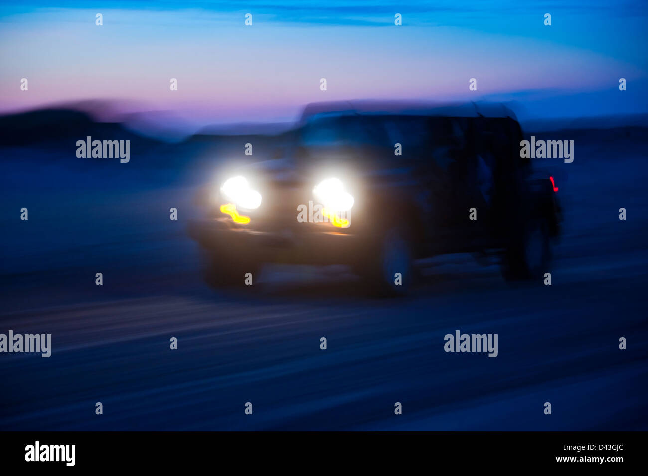 SUV riding off road at night. Stock Photo