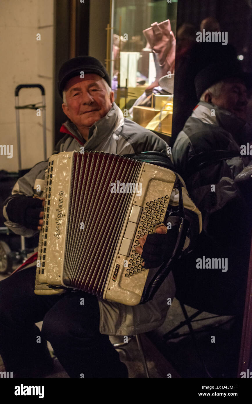 Old man playing the accordion in the cold winter evening at the Christmas market in Hamburg, Germany on December 1, 2012. Stock Photo