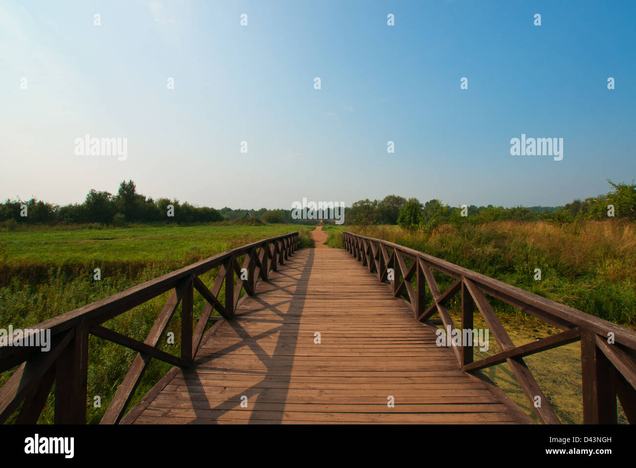 The wood bridge through the river to an old cathedral Stock Photo