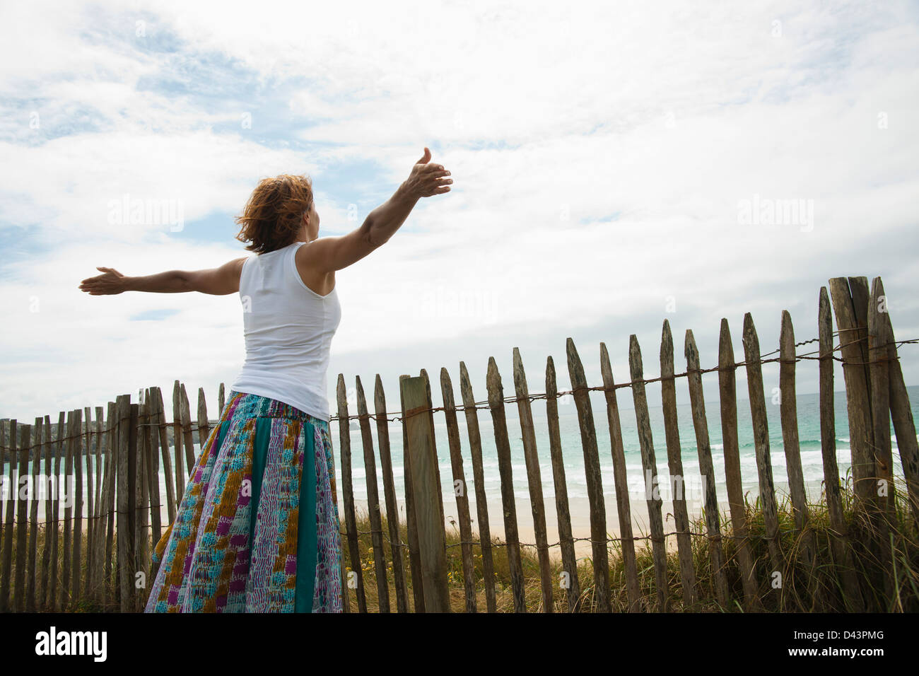 Woman with Open Arms at the Beach, Camaret-sur-Mer, Crozon Peninsula, Finistere, Brittany, France Stock Photo