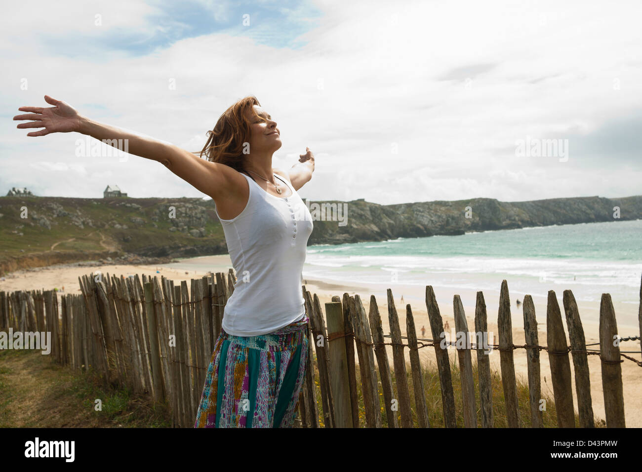Woman with Open Arms at the Beach, Camaret-sur-Mer, Crozon Peninsula, Finistere, Brittany, France Stock Photo